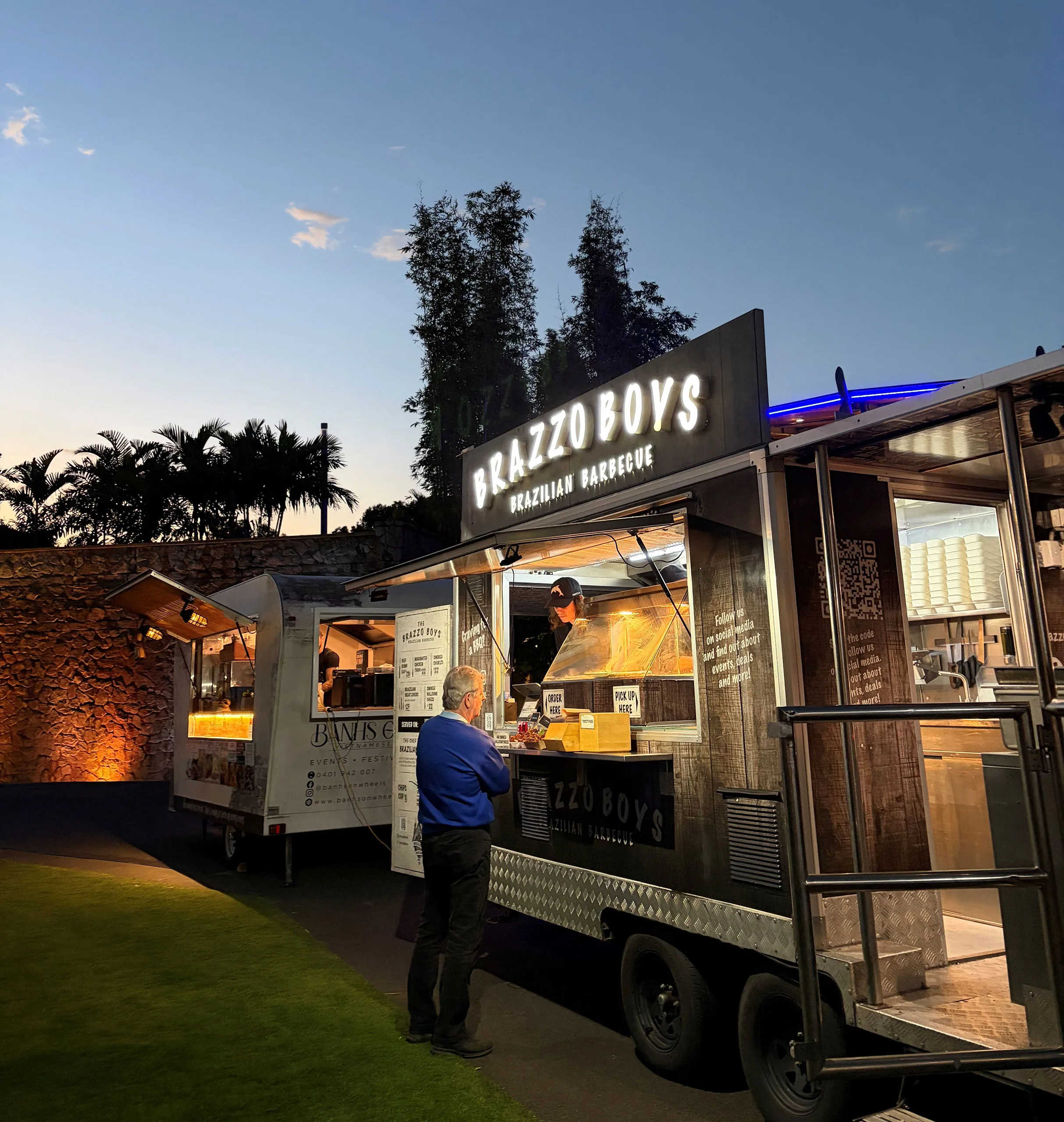 Brazzo Brothers Food Truck parked on a lawn lit up with a customer in front
